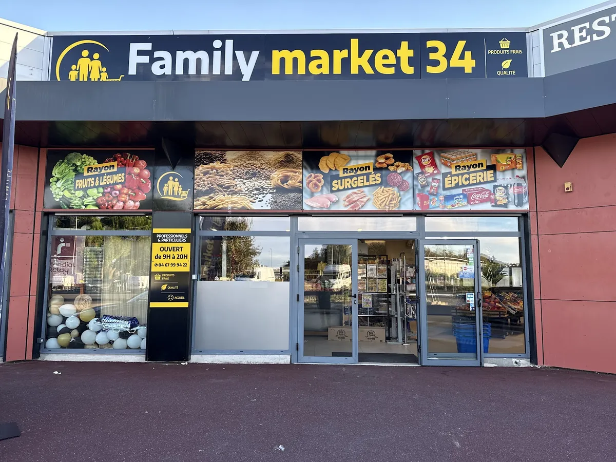 La devanture du Family Market 34 : enseigne bleu nuit et jaune, bandeaux fruits et légumes, surgelés et épicerie, affiche « ouvert de 9 h à 20 h ».